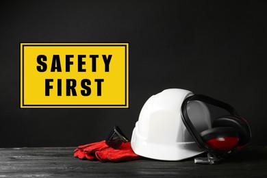 Image of Safety first, poster. Personal protective equipment on table against black background