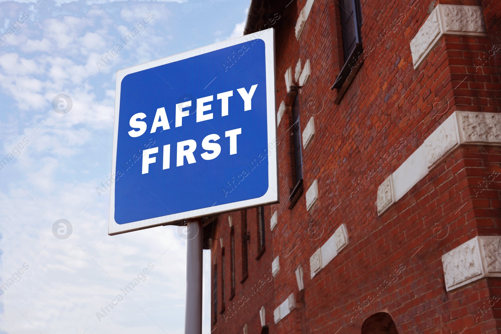 Image of Safety First sign on pole near building outdoors