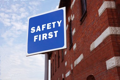 Image of Safety First sign on pole near building outdoors
