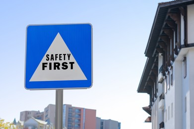 Image of Safety First sign on pole near building outdoors