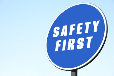 Image of Safety First sign on pole against blue sky outdoors