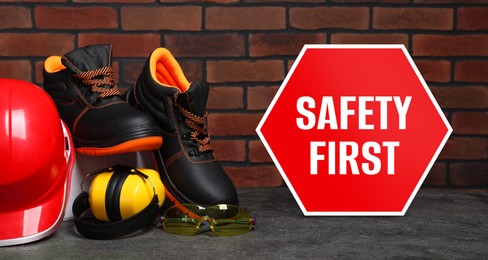Image of Safety first, poster. Personal protective equipment on stone surface near brick wall, banner design