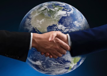 Image of Business partners shaking hands against globe. Deal, agreement, partnership, success
