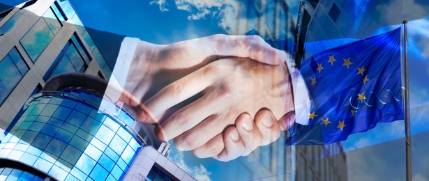 Image of Business partners shaking hands against office buildings, multiple exposure with flag. Deal, agreement, partnership, success