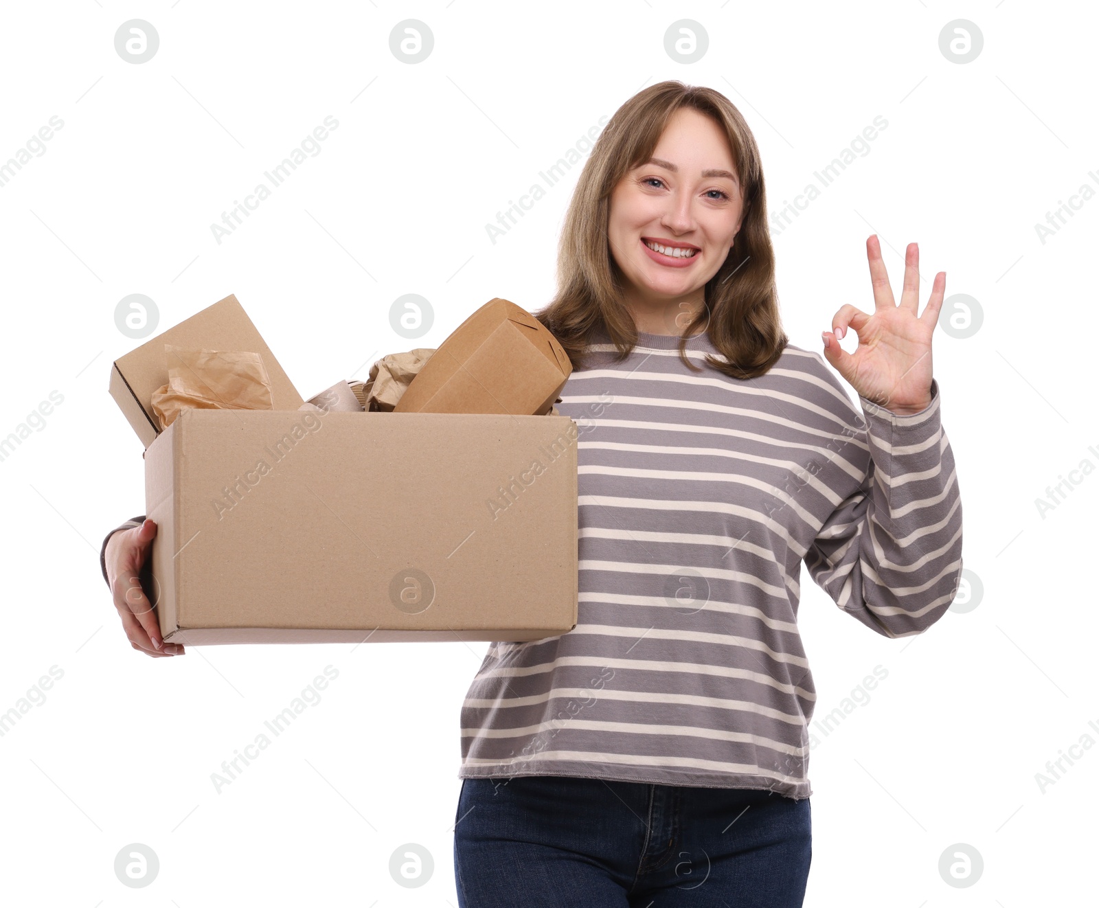 Photo of Recycling. Smiling woman holding cardboard box with different waste paper and showing Ok gesture on white background