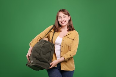 Photo of Recycling. Smiling woman with bag full of different waste paper on green background