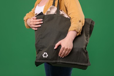 Photo of Recycling. Woman with bag full of different waste paper on green background, closeup