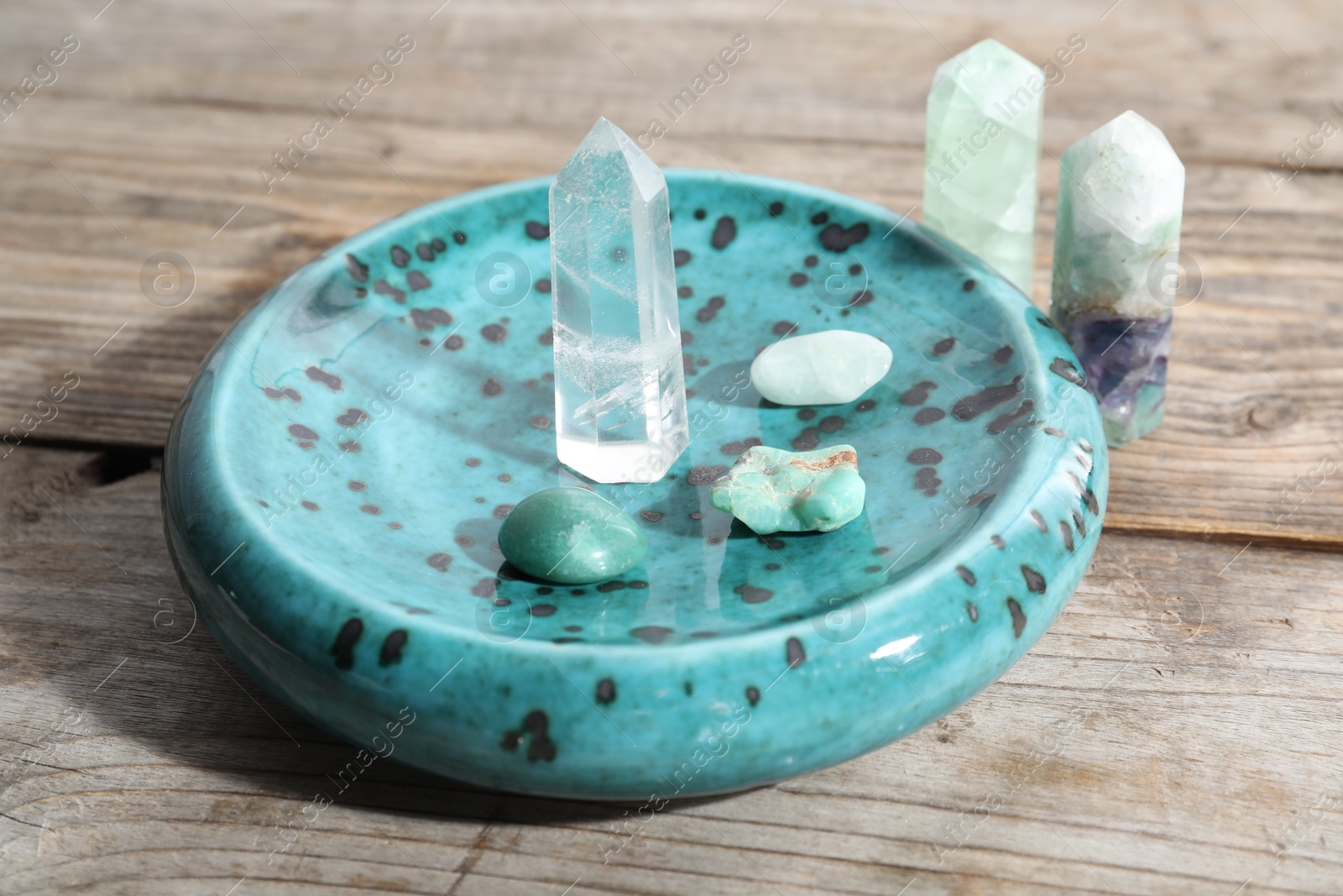 Photo of Many different healing stones on wooden table, closeup