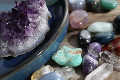 Photo of Many different healing stones on wooden table, closeup