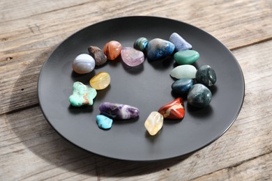 Photo of Many different healing stones on wooden table, closeup