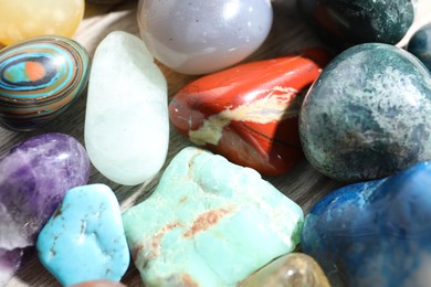 Photo of Many different healing stones on wooden table, closeup
