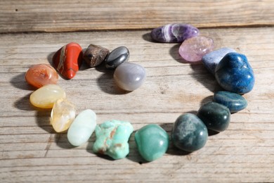Photo of Many different healing stones on wooden table, closeup