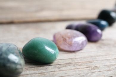 Photo of Many different healing stones on wooden table, closeup