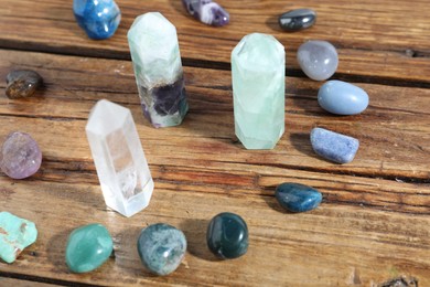 Photo of Different healing stones on wooden table, closeup