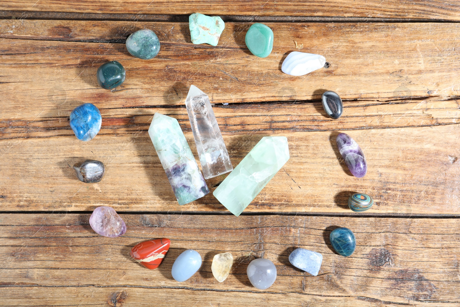 Different healing stones on wooden table, flat lay Photo of Different healing stones on wooden table, flat lay