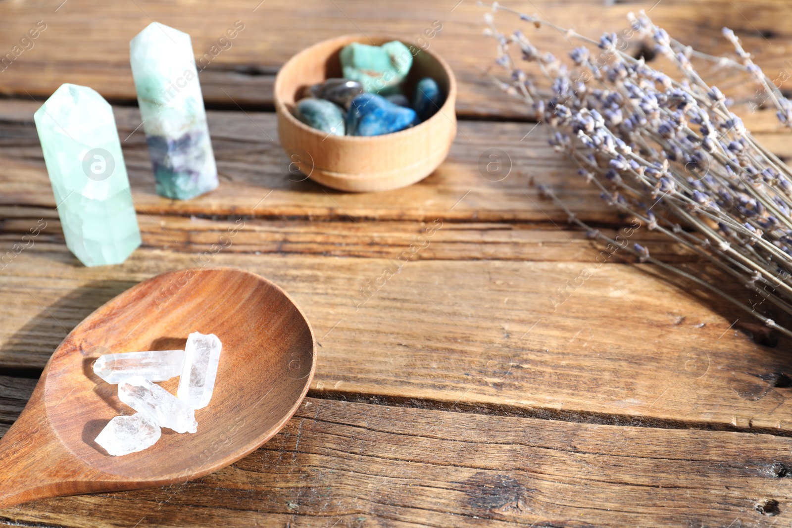 Different healing stones and lavender on wooden table, closeup Photo of Different healing stones and lavender on wooden table, closeup