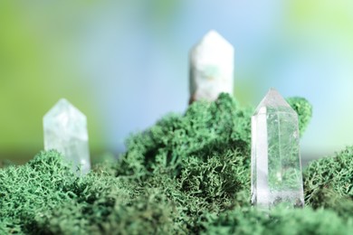 Photo of Healing stones on green moss against blurred background, closeup