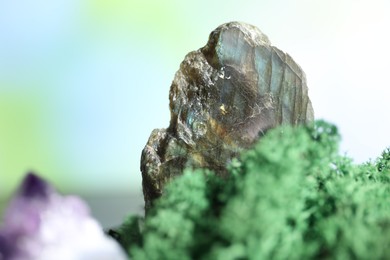 Photo of Healing stone on green moss against blurred background, closeup. Space for text