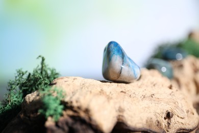 Photo of Healing stones and green moss on wood, closeup. Space for text