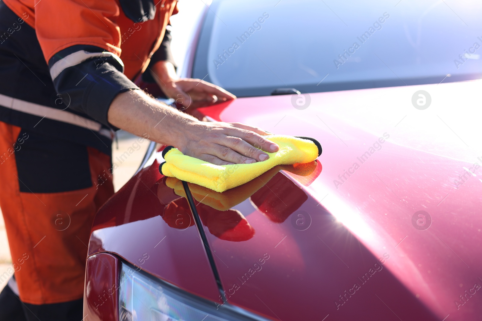 Man wiping car hood with yellow microfiber rag outdoors, closeup Photo of Man wiping car hood with yellow microfiber rag outdoors, closeup