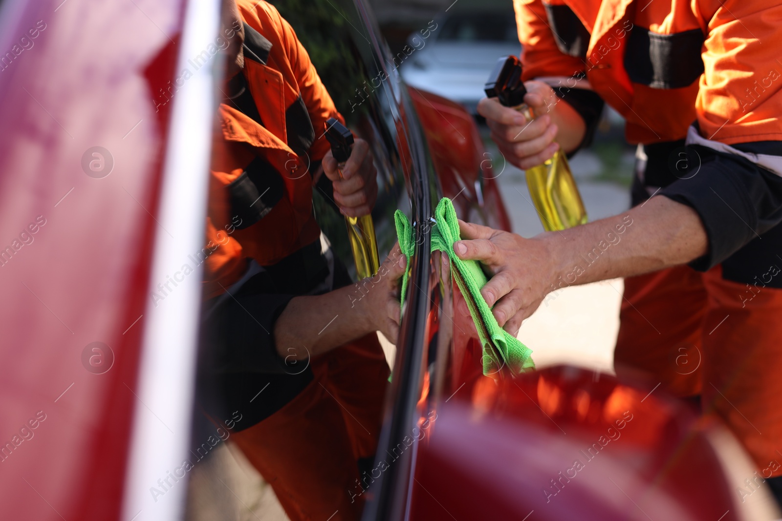 Man wiping car with green microfiber rag outdoors, closeup Photo of Man wiping car with green microfiber rag outdoors, closeup