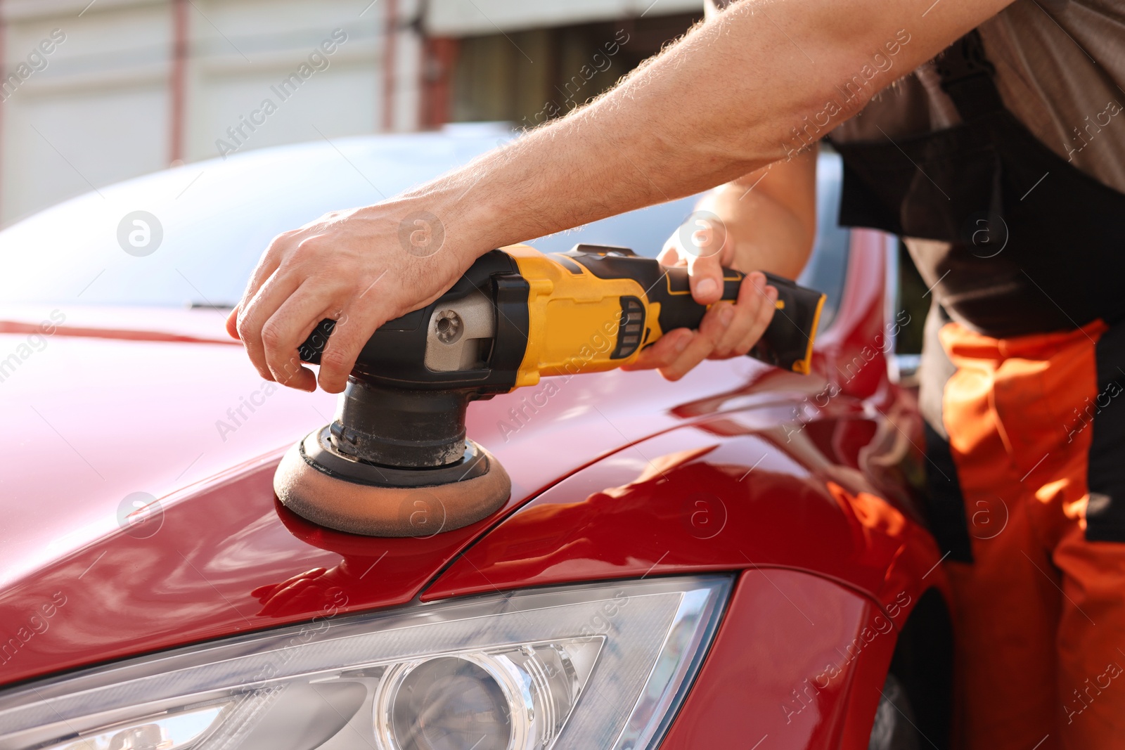 Man polishing car hood with orbital polisher outdoors, closeup Photo of Man polishing car hood with orbital polisher outdoors, closeup