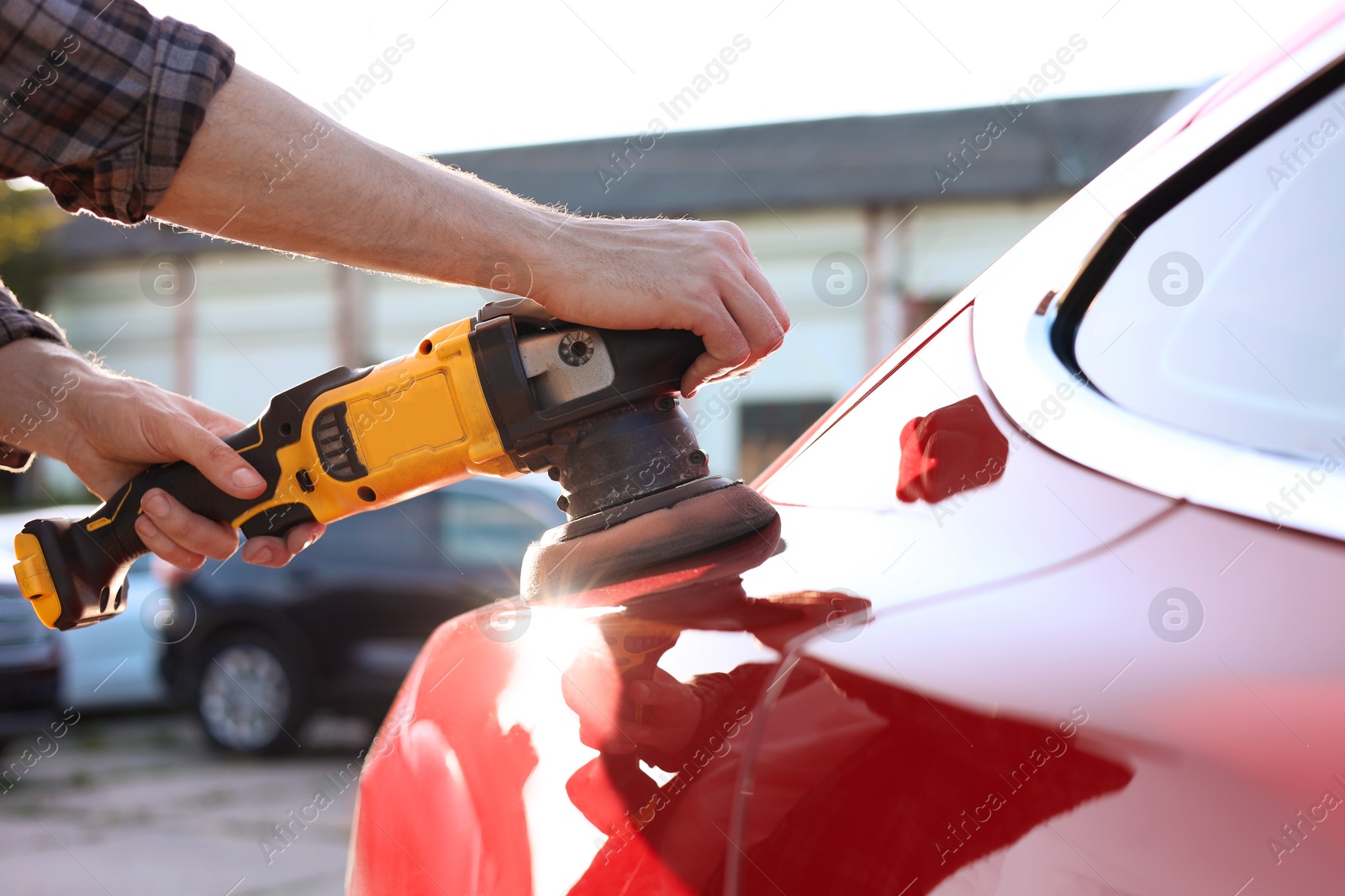Man polishing car with orbital polisher outdoors, closeup Photo of Man polishing car with orbital polisher outdoors, closeup