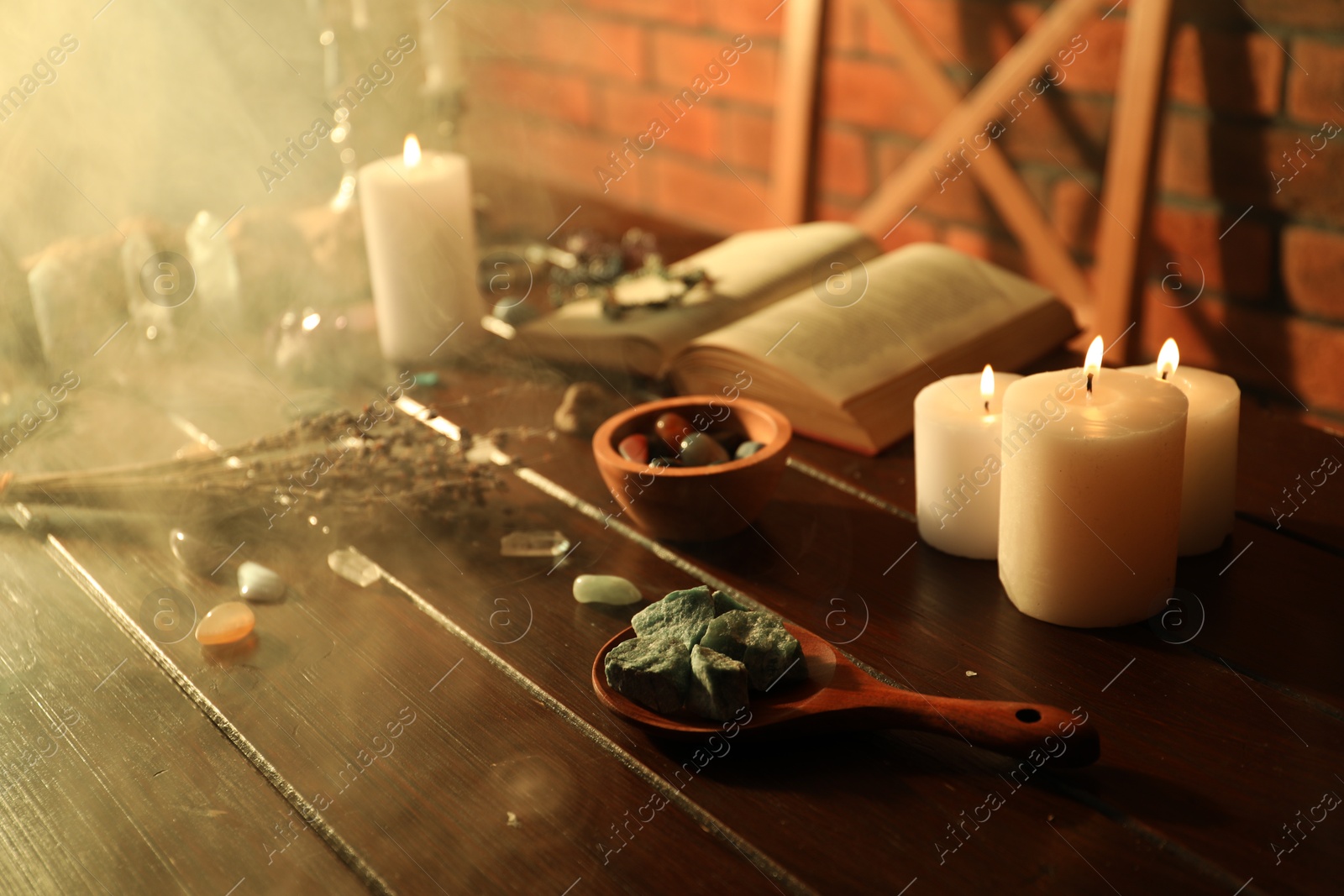 Photo of Healing stones, book, lavender and burning candles on wooden table