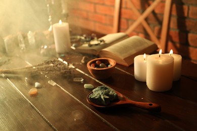 Photo of Healing stones, book, lavender and burning candles on wooden table
