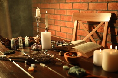 Photo of Healing stones, book, lavender and burning candles on wooden table