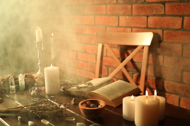 Photo of Healing stones, book, lavender and burning candles on wooden table