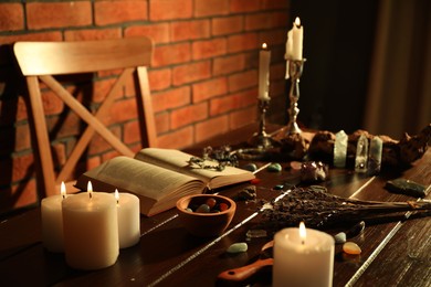 Photo of Healing stones, book, lavender and burning candles on wooden table