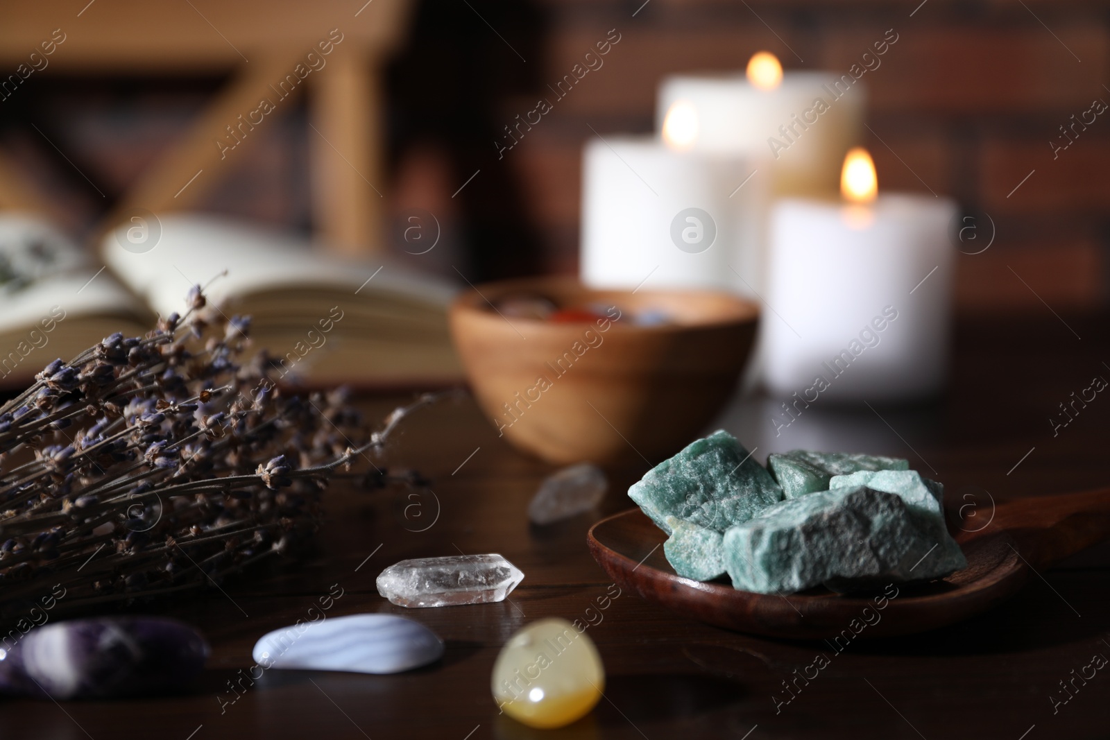 Healing stones, lavender and burning candles on dark table, closeup Photo of Healing stones, lavender and burning candles on dark table, closeup