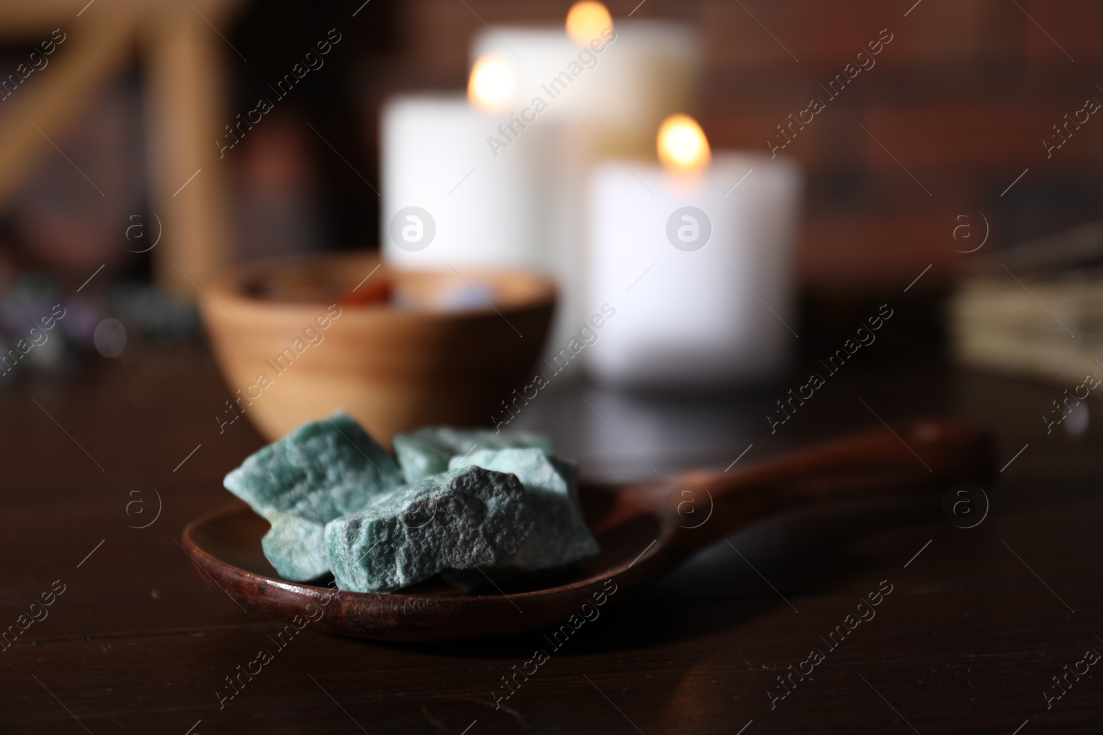 Healing stones and burning candles on dark table, closeup Photo of Healing stones and burning candles on dark table, closeup