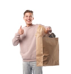 Photo of Recycling. Smiling man with bag full of different waste paper showing thumbs up on white background