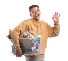 Photo of Recycling. Smiling man holding plastic box with different waste paper and showing OK gesture on white background