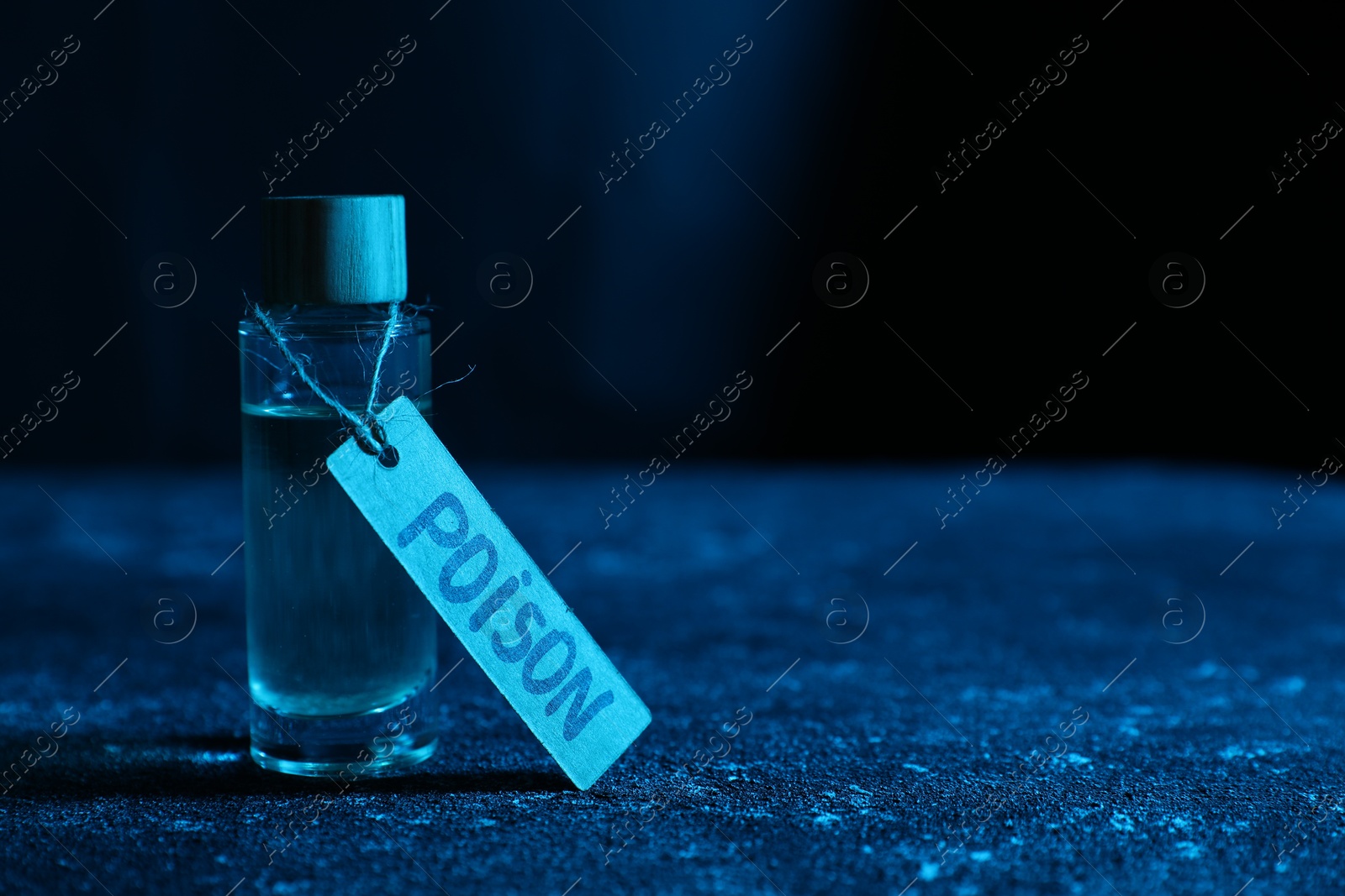 Photo of Bottle with poison on textured table against dark background, closeup. Space for text