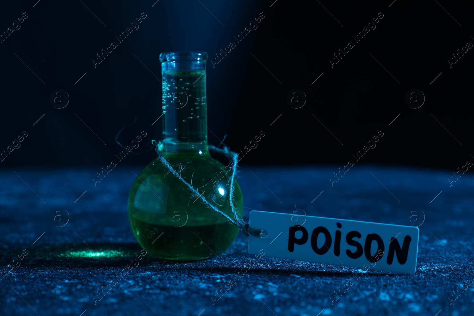 Flask with poison on textured table against dark background, closeup Photo of Flask with poison on textured table against dark background, closeup