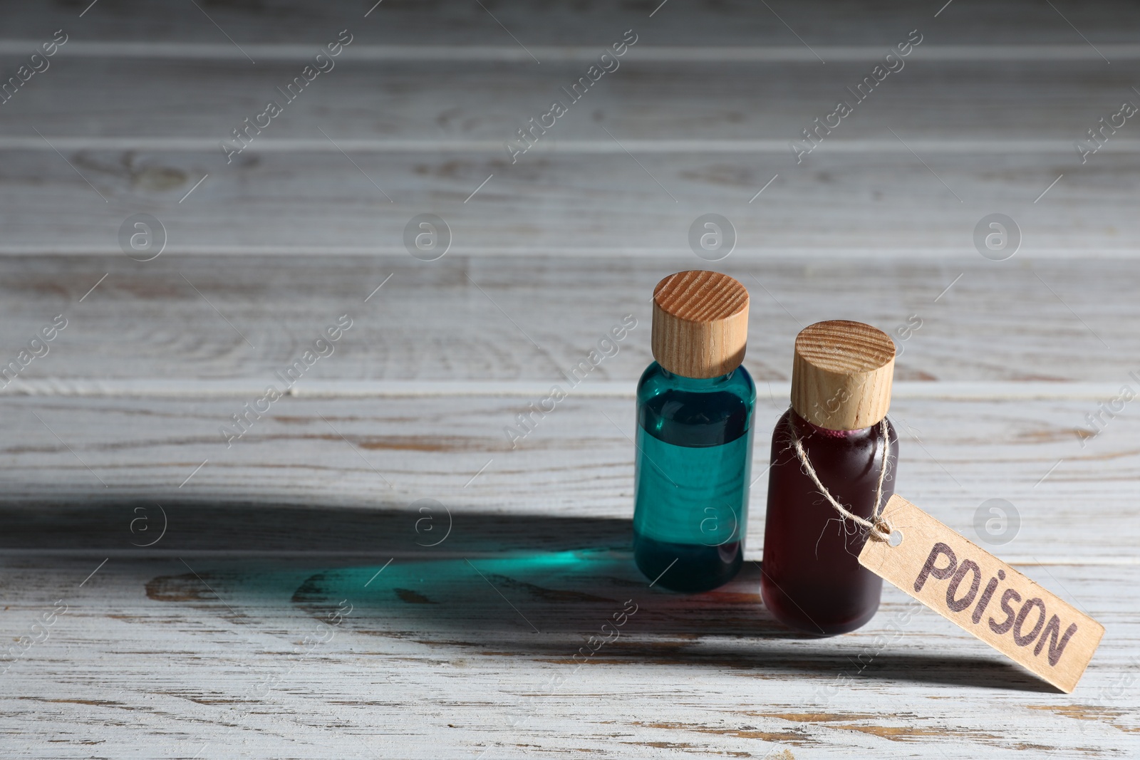 Two bottles of poisons on wooden table, space for text Photo of Two bottles of poisons on wooden table, space for text