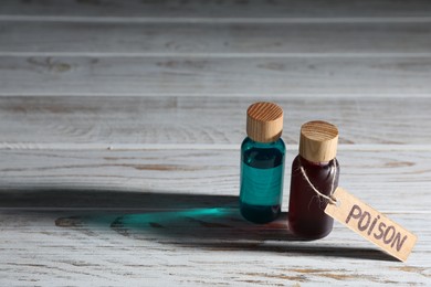 Photo of Two bottles of poisons on wooden table, space for text
