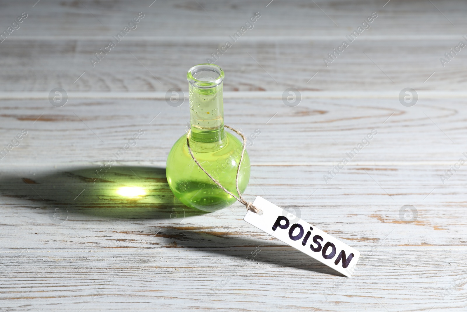 Flask with poison on wooden table, closeup Photo of Flask with poison on wooden table, closeup