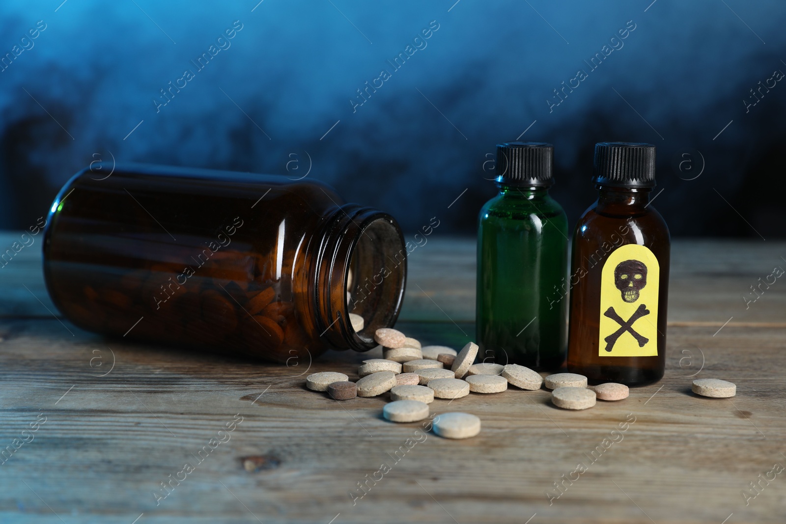 Bottles of poisons with warning sign on wooden table against dark background with smoke, closeup Photo of Bottles of poisons with warning sign on wooden table against dark background with smoke, closeup