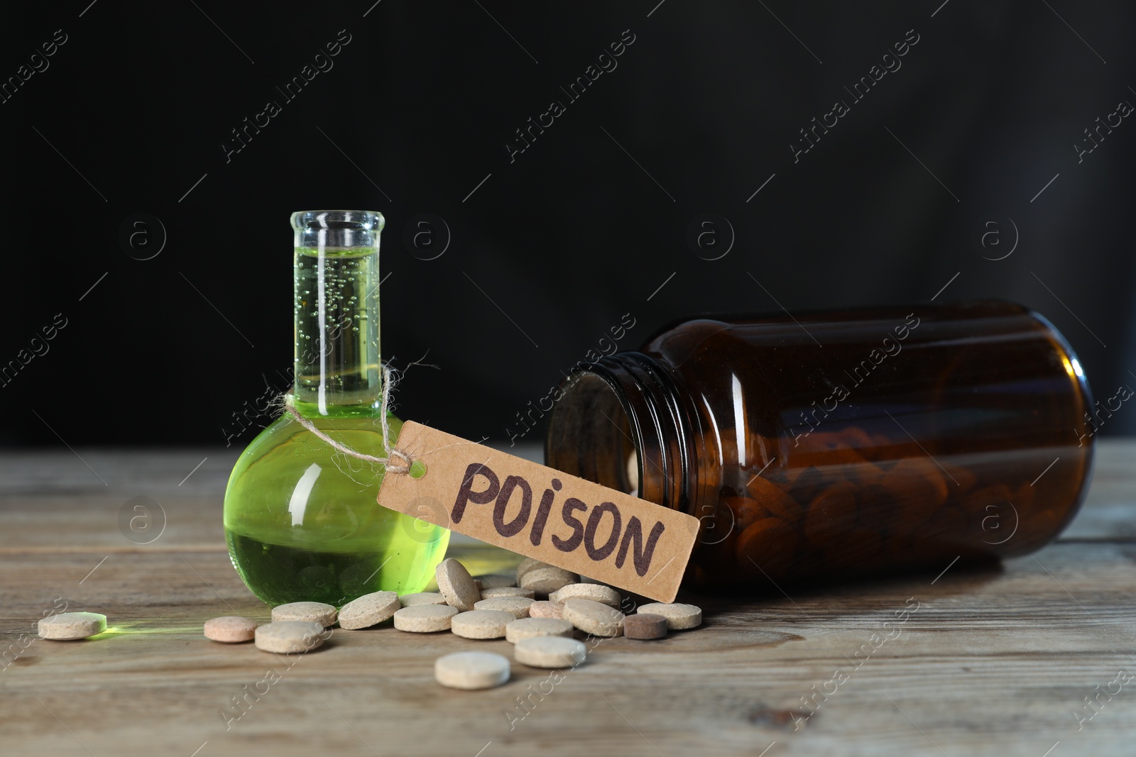 Photo of Bottles of poisons on wooden table against dark background, closeup