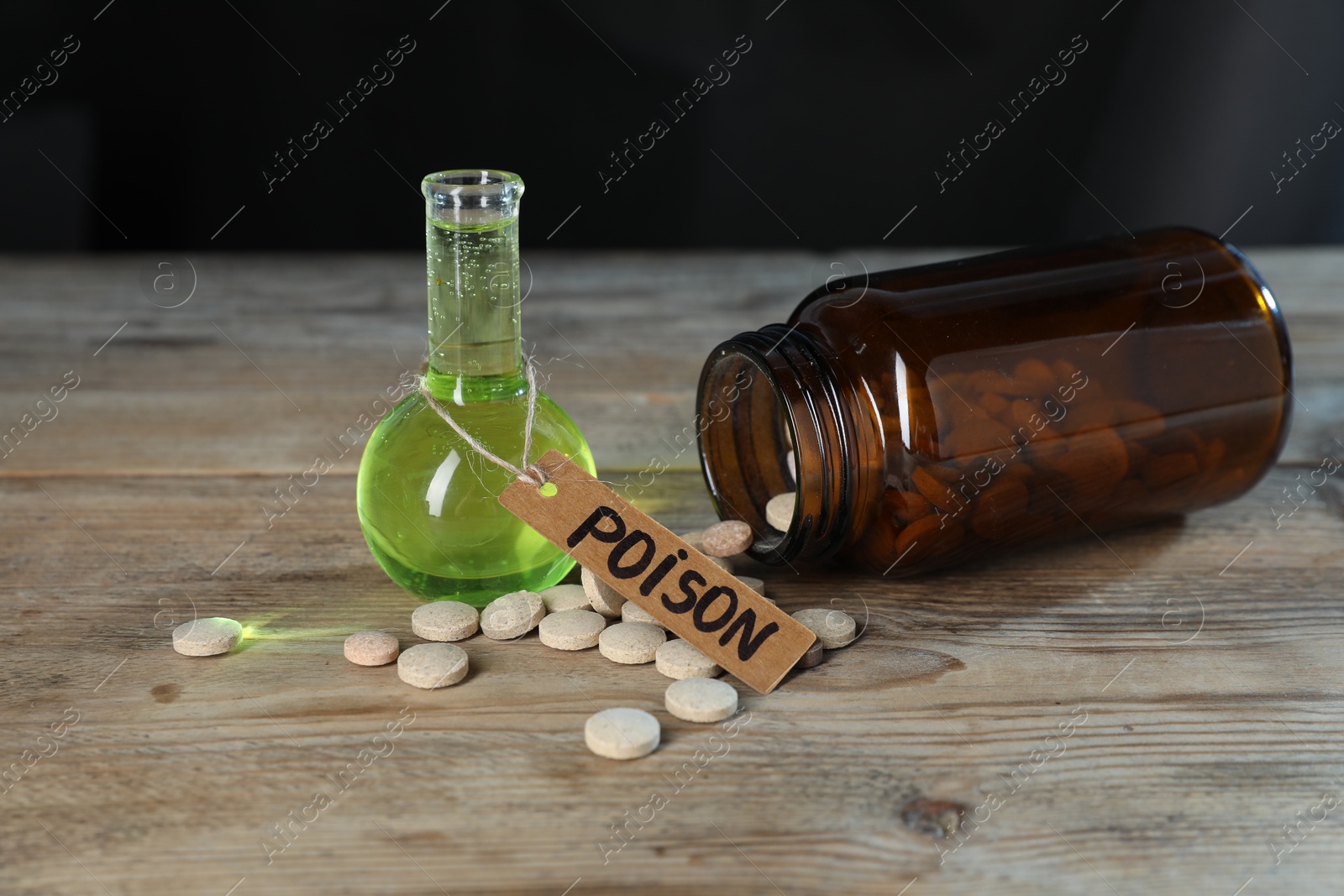 Bottles of poisons on wooden table against dark background, closeup Photo of Bottles of poisons on wooden table against dark background, closeup