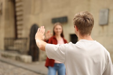 Photo of Goodbye. Man waving to his girlfriend outdoors, selective focus. Space for text