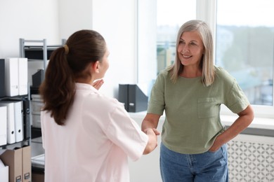 Photo of Cooperation and teamwork. Women shaking hands in office