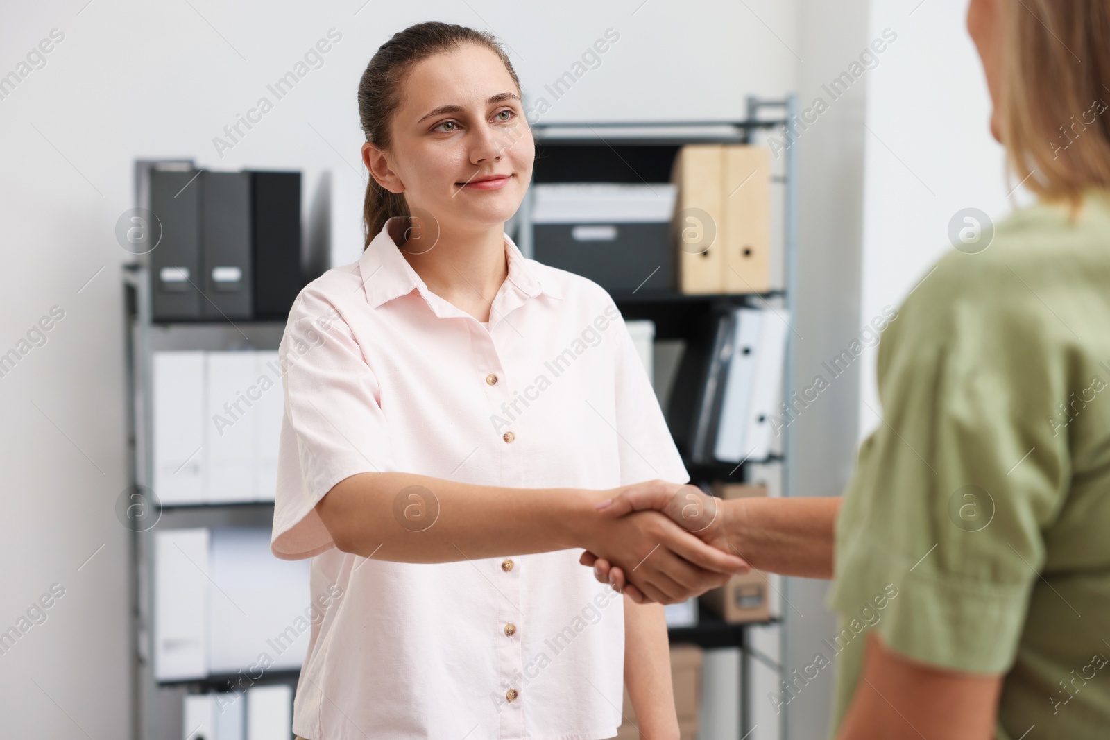 Photo of Cooperation and teamwork. Women shaking hands in office