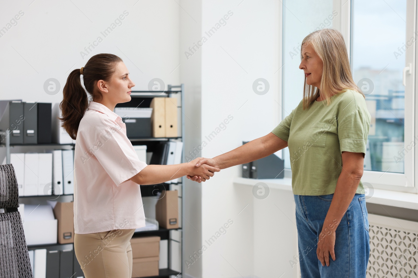 Cooperation and teamwork. Women shaking hands in office Photo of Cooperation and teamwork. Women shaking hands in office