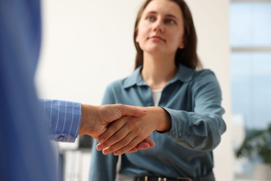Photo of Cooperation. Women shaking hands in office, selective focus