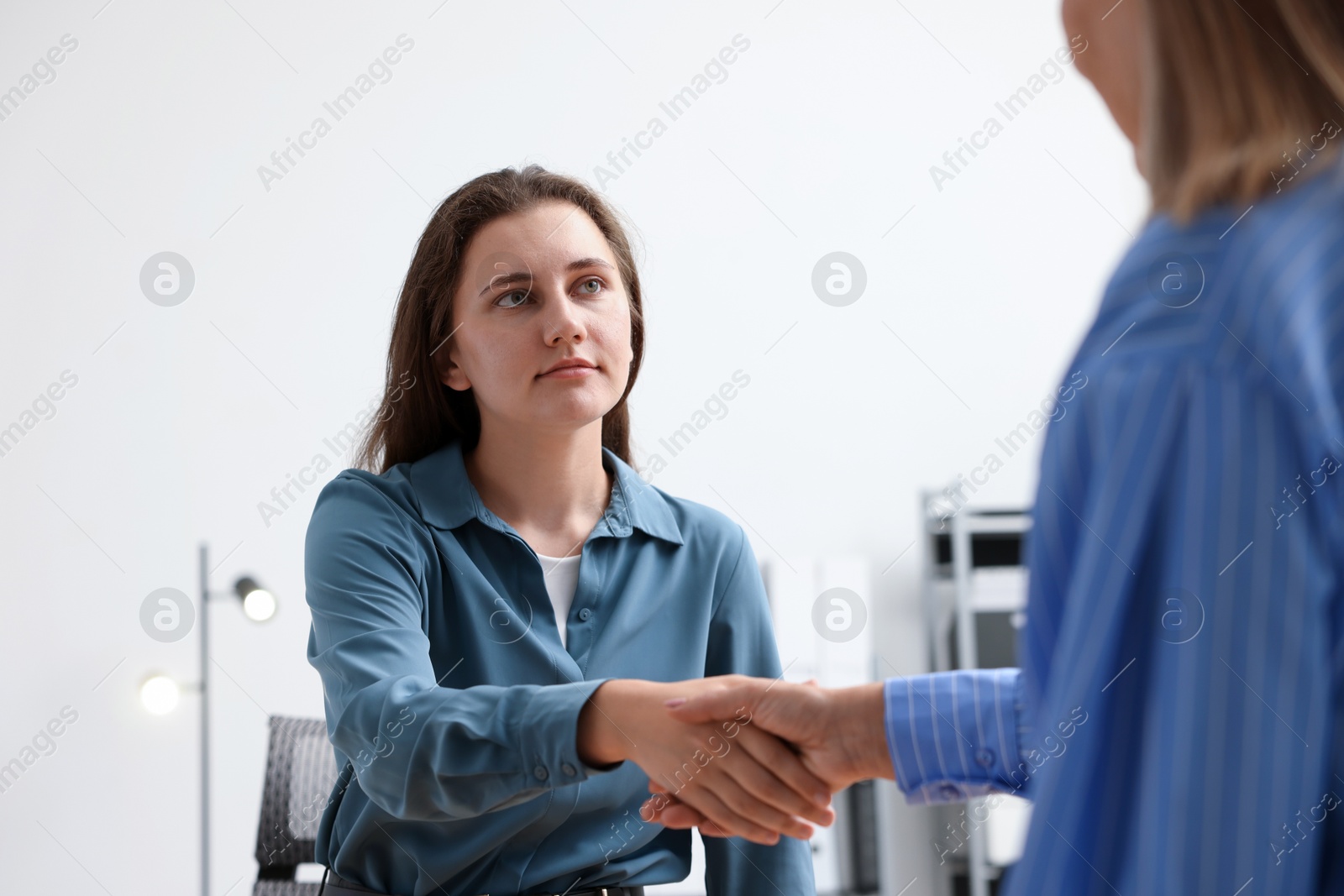 Photo of Cooperation and teamwork. Women shaking hands in office
